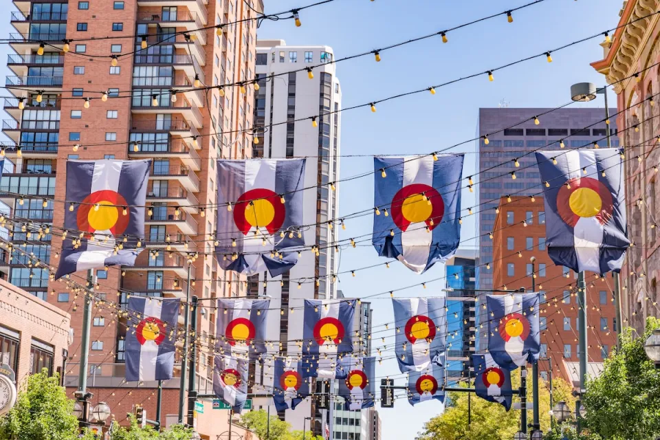 Colorado flags draped between buildings in downtown Denver, Colorado.